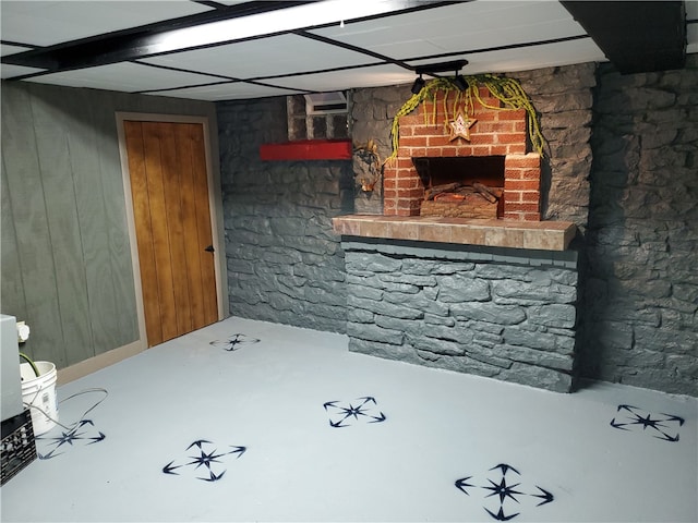 basement with a fireplace and wood walls