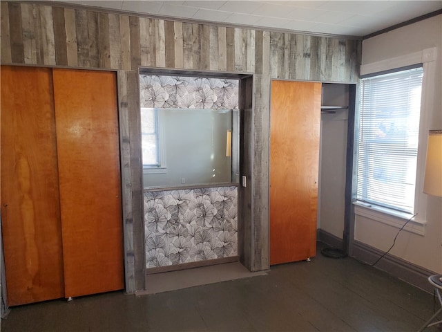 unfurnished bedroom featuring wood walls