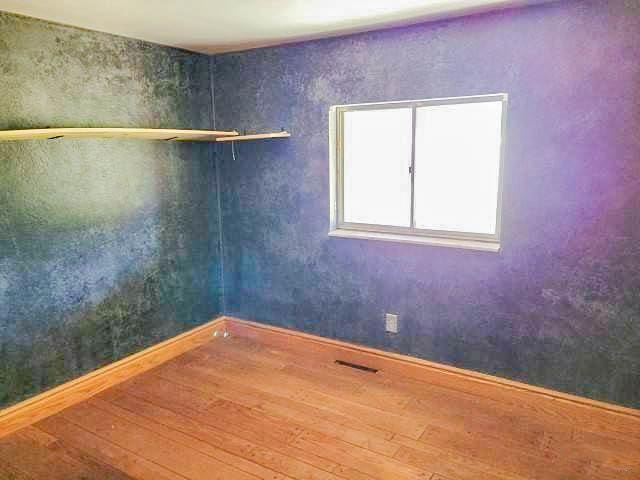 unfurnished room featuring wood finished floors and baseboards
