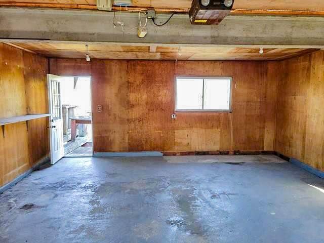misc room with unfinished concrete floors and wood walls