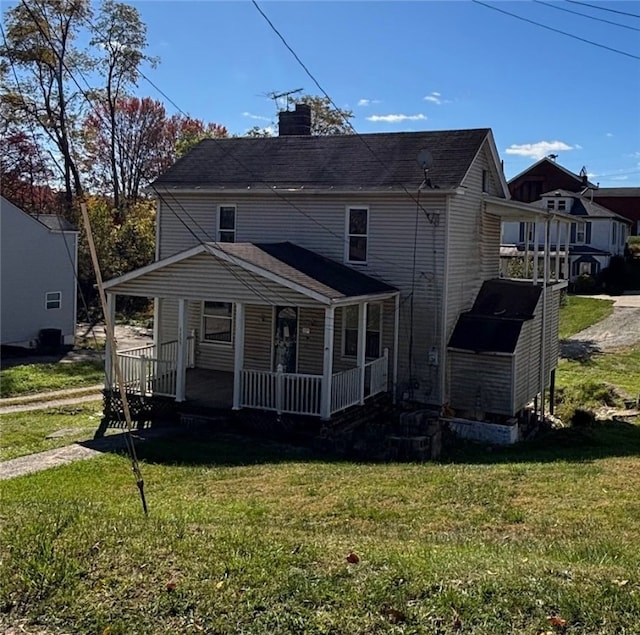 back of house featuring a porch and a lawn