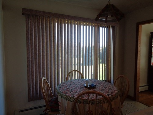 dining space with light hardwood / wood-style flooring and a baseboard heating unit