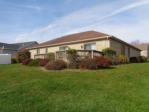 view of home's exterior with a lawn and a deck