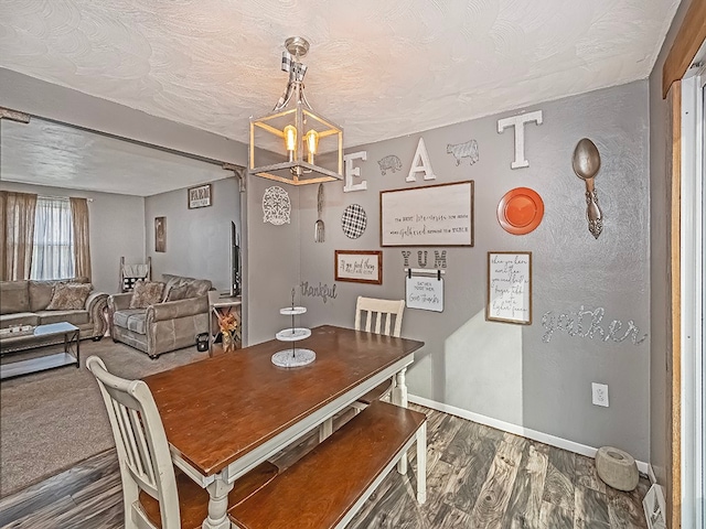 dining room featuring a textured ceiling, dark hardwood / wood-style floors, and a notable chandelier