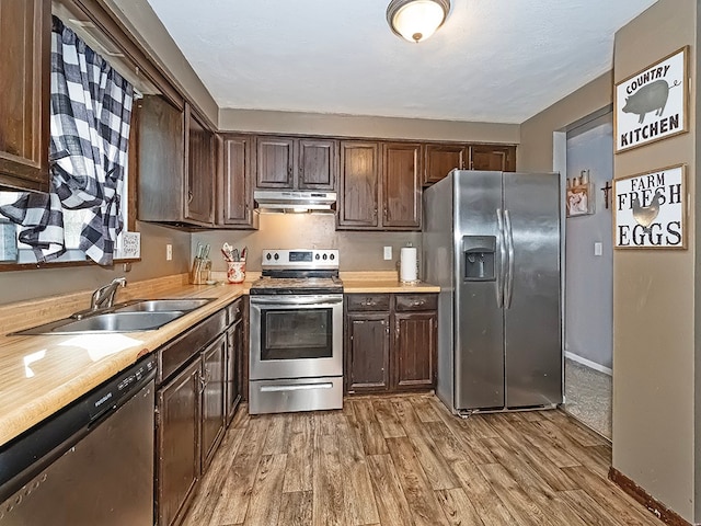 kitchen featuring dark brown cabinets, light wood-type flooring, stainless steel appliances, and sink