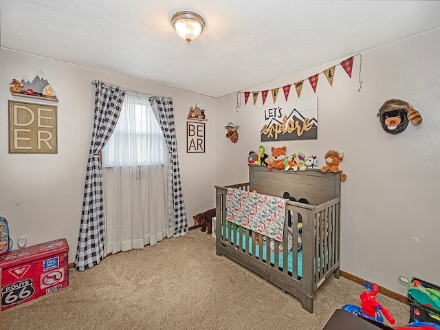 bedroom with a crib and carpet floors