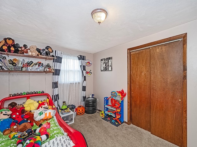 bedroom featuring carpet floors, a textured ceiling, and a closet