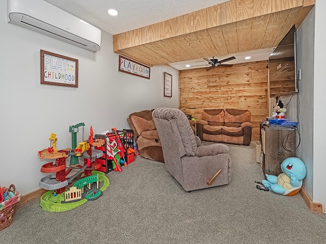 recreation room with a wall mounted AC, ceiling fan, and carpet floors