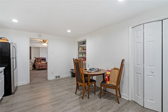 dining room featuring light hardwood / wood-style flooring, ceiling fan, and built in features