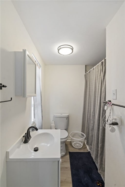 bathroom featuring toilet, vanity, a shower with shower curtain, and hardwood / wood-style flooring