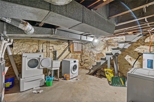 basement with electric water heater and independent washer and dryer