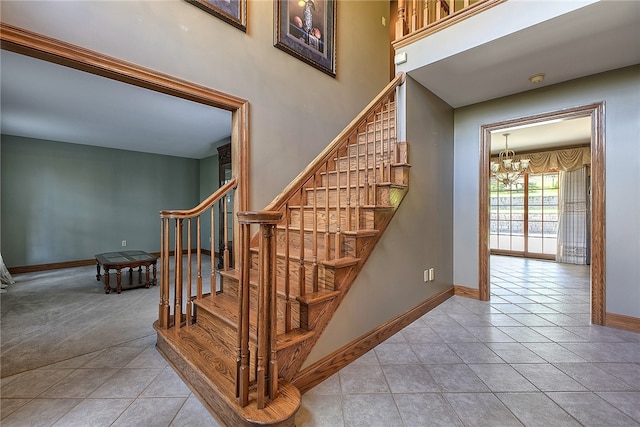 stairs with a chandelier and tile patterned floors