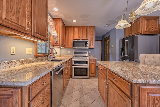 kitchen featuring light tile patterned flooring, appliances with stainless steel finishes, light stone countertops, sink, and a center island