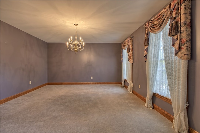 carpeted spare room featuring a notable chandelier