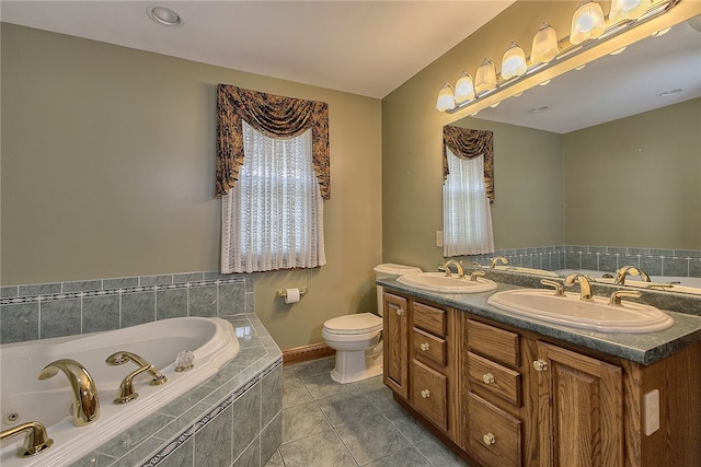 bathroom with toilet, vanity, tiled bath, and tile patterned floors