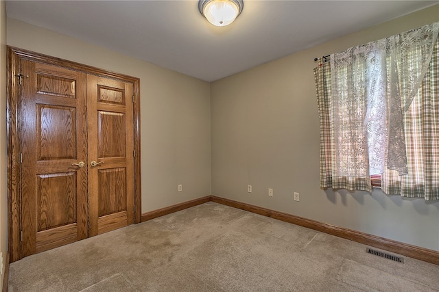 spare room with a wealth of natural light and light carpet