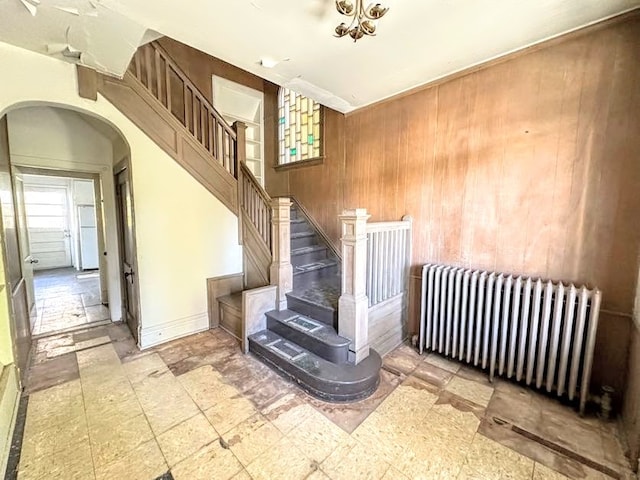 stairway featuring wood walls and radiator