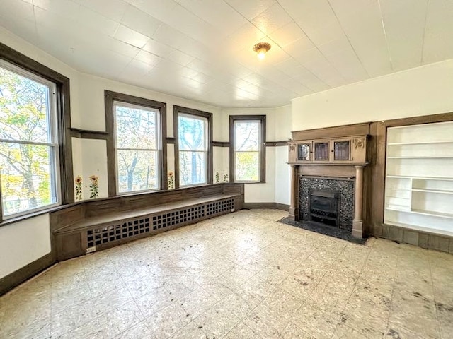 unfurnished living room featuring a wealth of natural light and radiator