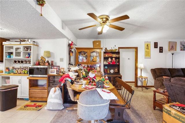 dining space with a textured ceiling, ceiling fan, and light tile patterned floors