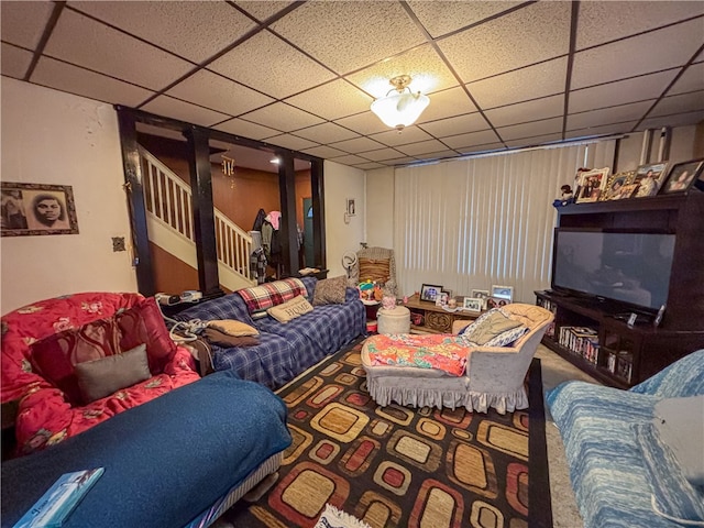 living room with a drop ceiling and carpet