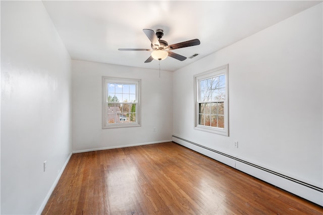 spare room with plenty of natural light, light wood-type flooring, and a baseboard radiator