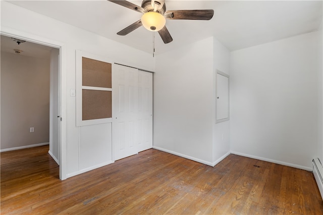 unfurnished bedroom featuring hardwood / wood-style floors, ceiling fan, a baseboard radiator, and a closet