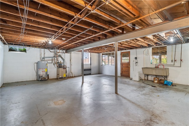 basement with plenty of natural light, sink, and gas water heater