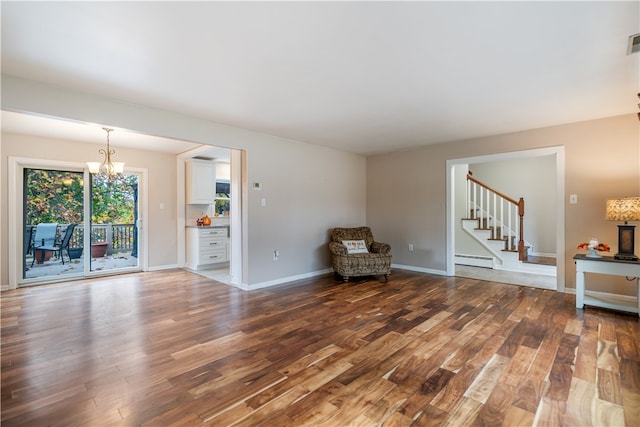 unfurnished room featuring hardwood / wood-style floors, a baseboard radiator, and an inviting chandelier