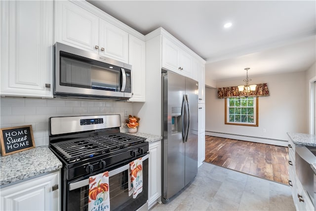 kitchen with a baseboard radiator, stainless steel appliances, white cabinets, a notable chandelier, and light wood-type flooring