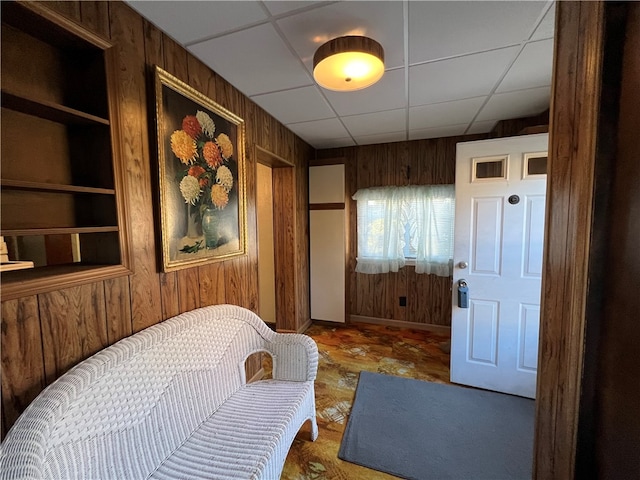 bedroom with a drop ceiling and wooden walls