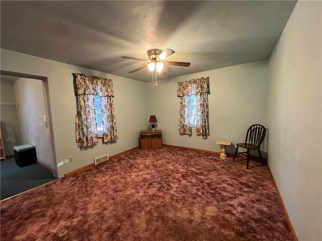 unfurnished room with ceiling fan and carpet