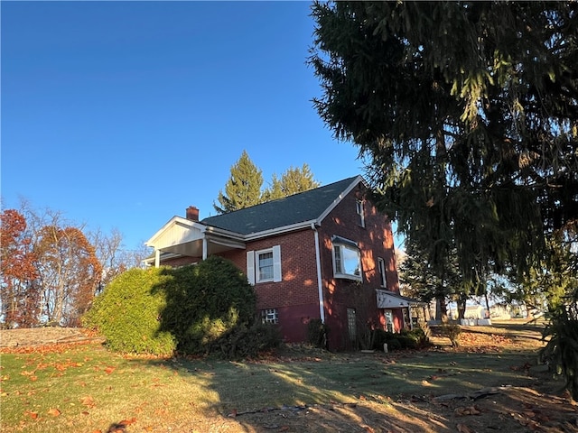 view of side of home with a yard