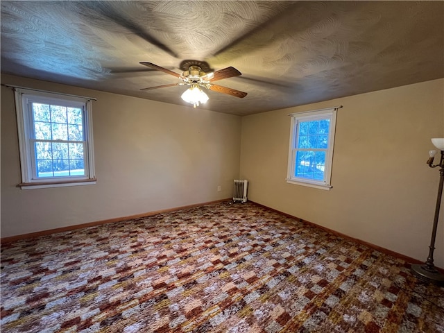 spare room featuring radiator and ceiling fan