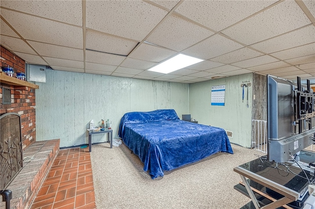 bedroom with a brick fireplace and a drop ceiling