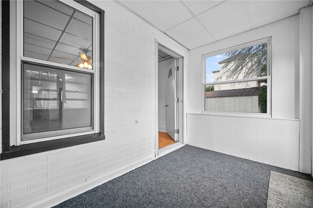 interior space with a drop ceiling and carpet floors