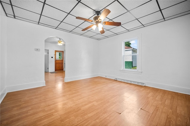 spare room featuring ceiling fan, light hardwood / wood-style flooring, a baseboard heating unit, and a drop ceiling