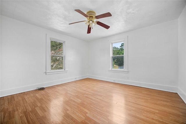 unfurnished room with light wood-type flooring, ceiling fan, and plenty of natural light