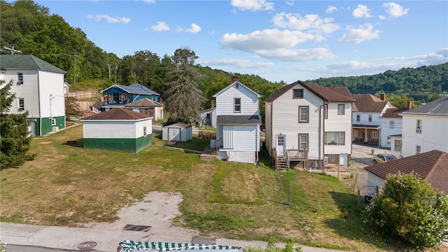 back of property featuring a yard and a storage shed