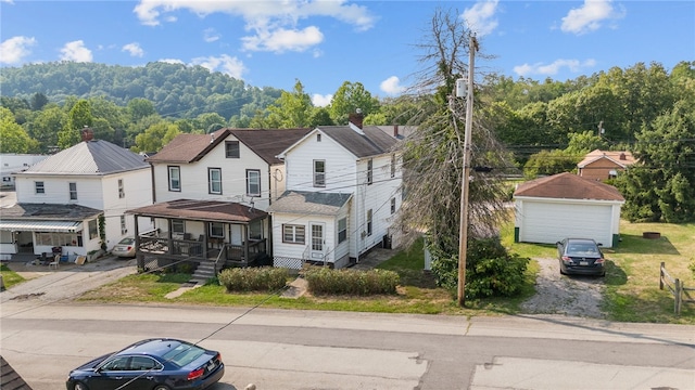 view of front of property featuring an outbuilding, a garage, and a porch