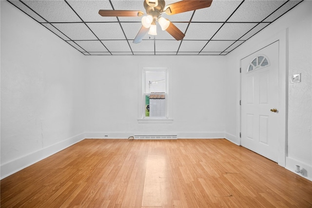 empty room with a paneled ceiling, ceiling fan, and light hardwood / wood-style flooring