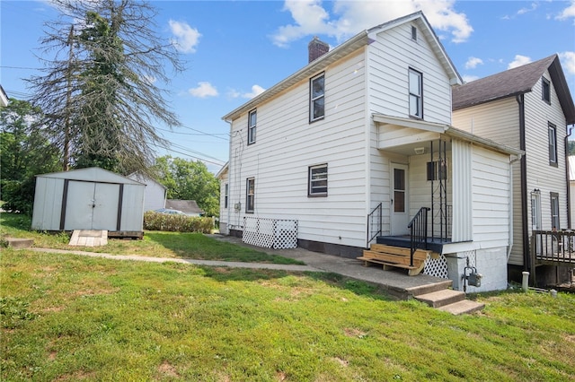 back of property with a lawn and a shed