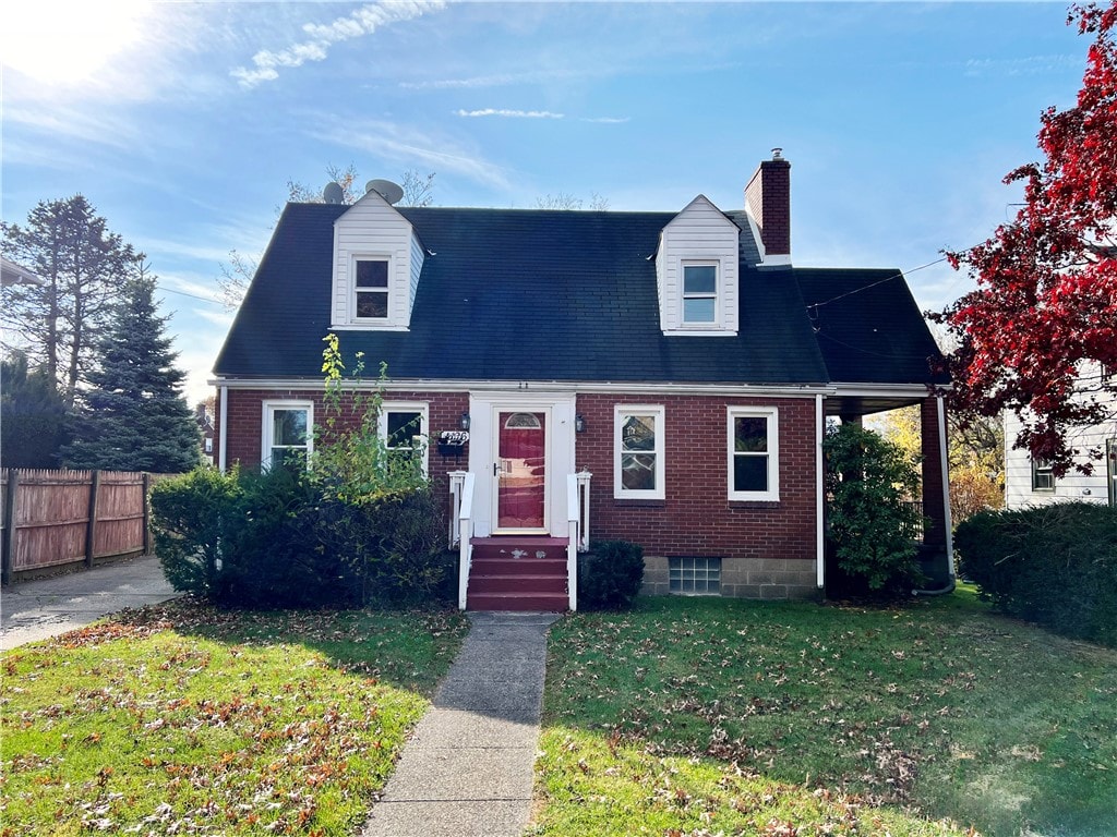 new england style home featuring a front yard