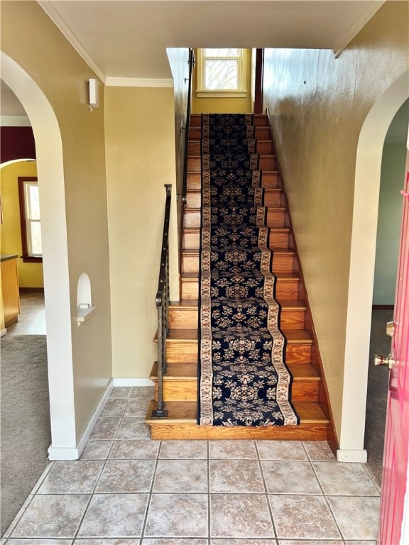 stairway featuring tile patterned floors and crown molding