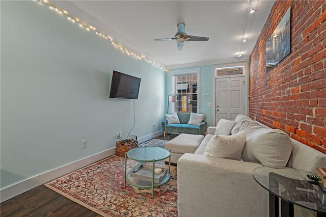 living room featuring ceiling fan, wood-type flooring, ornamental molding, and brick wall