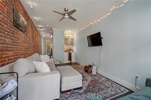 living room with crown molding, hardwood / wood-style floors, beverage cooler, ceiling fan, and brick wall