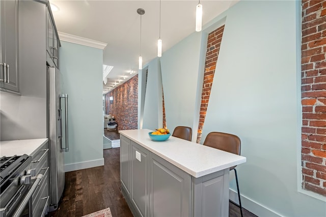 kitchen featuring gray cabinetry, decorative light fixtures, stainless steel refrigerator, dark hardwood / wood-style flooring, and brick wall