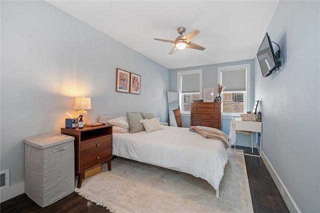 bedroom featuring ceiling fan, cooling unit, and dark hardwood / wood-style flooring