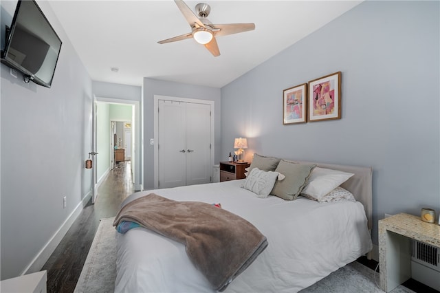 bedroom featuring dark wood-type flooring, ceiling fan, and a closet