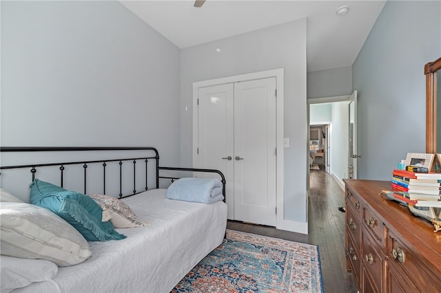 bedroom with dark wood-type flooring, a closet, and ceiling fan