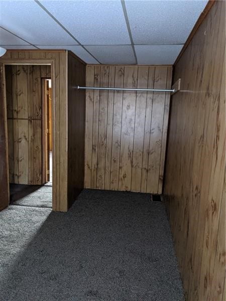 interior space featuring wood walls and a paneled ceiling